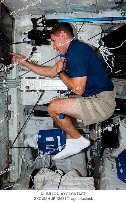 NASA astronaut Michael Hopkins, Expedition 37 flight engineer, performs Body Mass Measurement activities using the Space Linear Acceleration Mass Measurement...