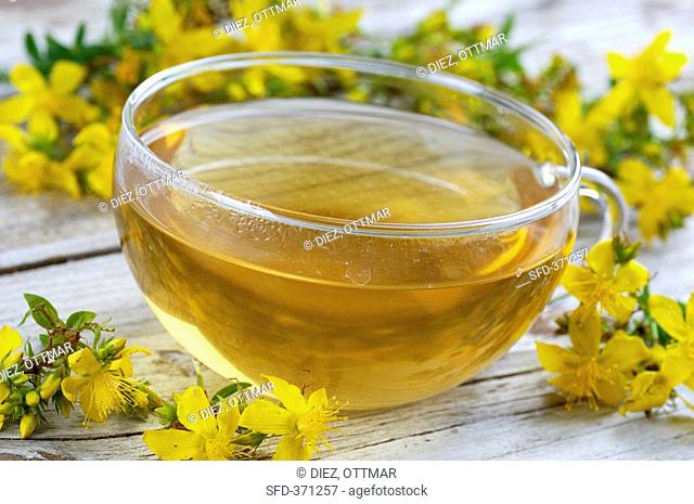 A cup of St. John's wort tea and St. John's wort flowers