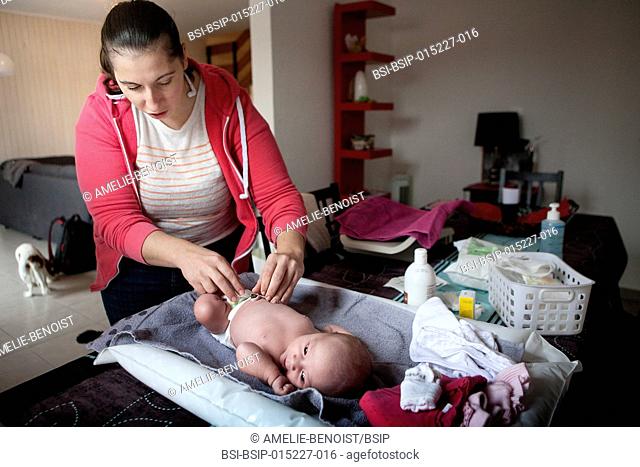 Reportage on an independent midwife during post-partum home visits. The midwife cleans the umbilical cord