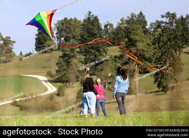 03 October 2023, Baden-Württemberg, Hayingen: Two women and a girl fly a kite on the Swabian Alb Photo: Thomas Warnack/dpa