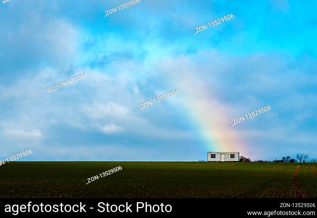 The trailer with a rainbow on a field in stormy weather