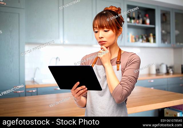 happy woman in apron with tablet pc computer