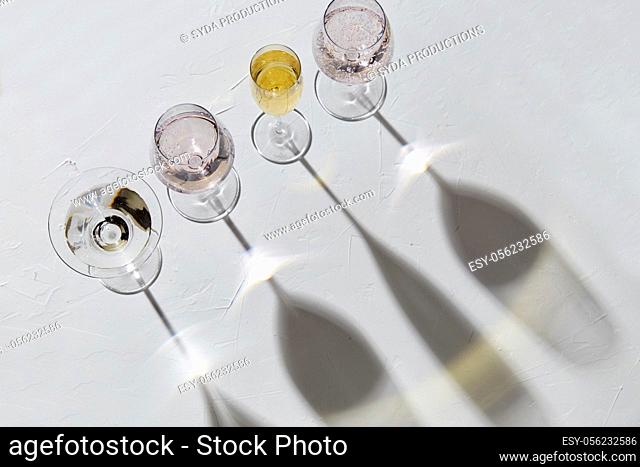 wine glasses dropping shadows on white surface