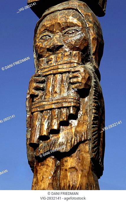 A wooden carving in Los Dominicos, Chile depicting a Peruvian Indian playing a pan flute. - LOS DOMINICOS, SANTIAGO PROVINCE, CHILE, 12/03/2010