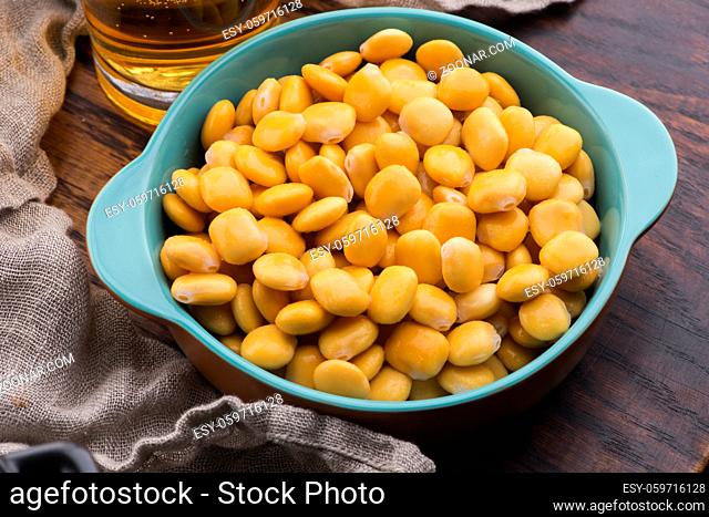 Tasty lupins and glass of beer. Beverage, legume