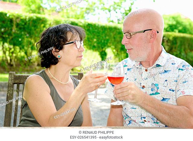 senior couple drinking a glass of wine in the garden