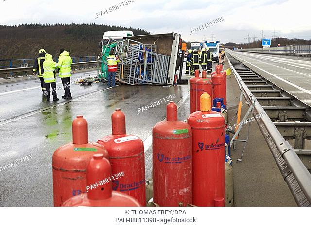 Fire fighters secure the gas bottles that fell of a small truck which toppled over on the motorway A61 near Winningen, Germany, 7 March 2017