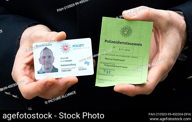 03 May 2021, Lower Saxony, Hanover: Police Chief Superintendent Marcus Kahlmeyer shows his new electronic service ID card (l) and his old green service ID card...