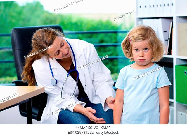 female pediatrician in white lab coat examined little girl