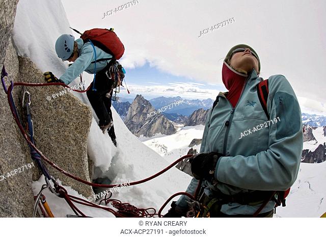 A female climber ascends the Northeast Ridge - North Howser, Bugaboos, BC