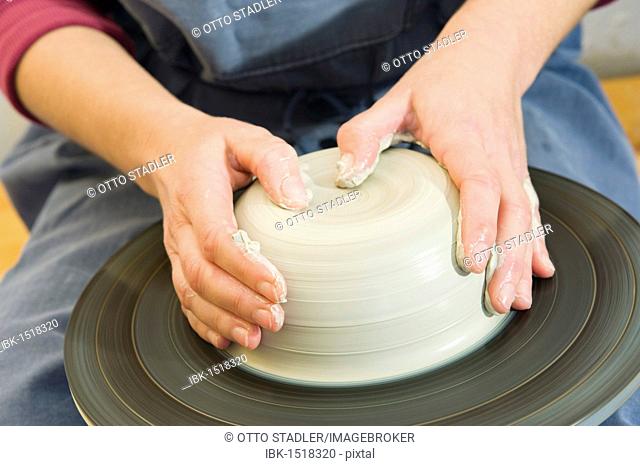 Ceramic artist working in her workshop with a potter's wheel, turning and centering, Geisenhausen, Bavaria, Germany, Europe