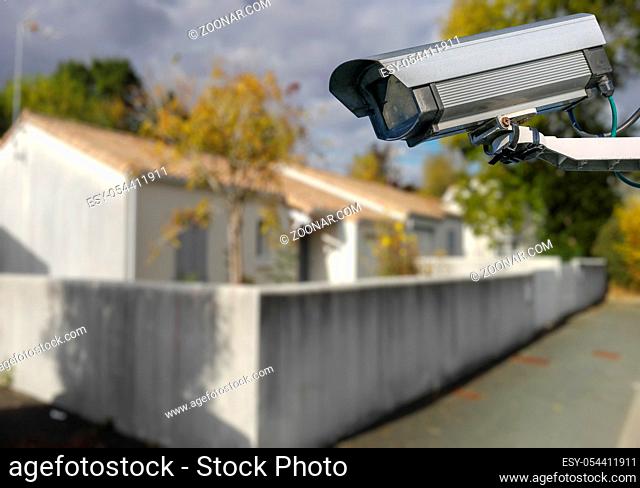 security CCTV camera or surveillance system with individual house on blurry background
