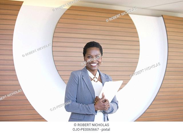 Businesswoman posing with paperwork in office