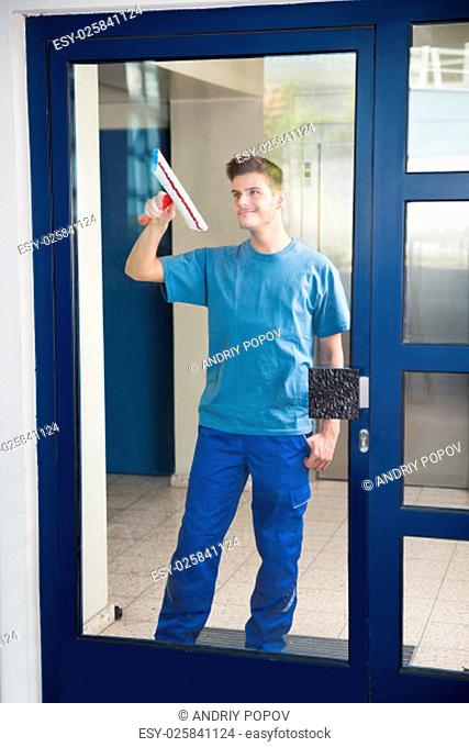 Young Happy Worker Cleaning Glass With Mop