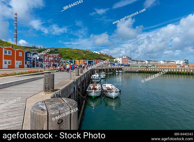 Colourful lobster stalls, former fishermen's huts, inland harbour, barge boats, waterside promenade, stalls for sale, blue sky, radio tower, Helgoland