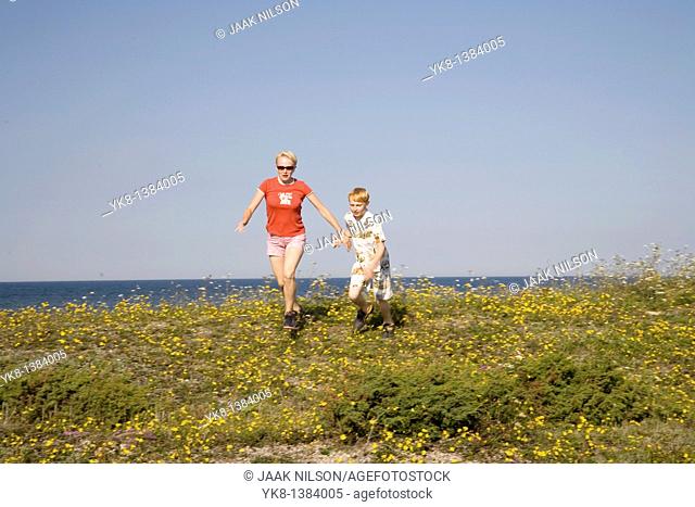Woman and Kid Running Hand in Hand on Saaremaa Coast, Saare County, Estonia