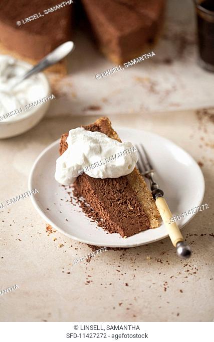 A slice of chocolate cheesecake with whipped cream
