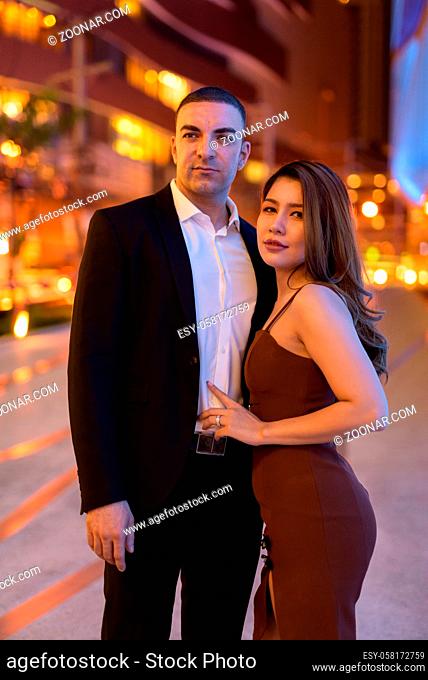Portrait of couple outdoors at night in the city