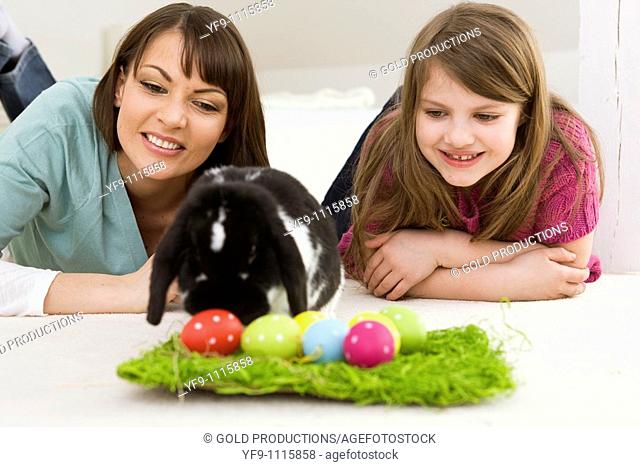 Mother and daughter with Easter Eggs and rabbit