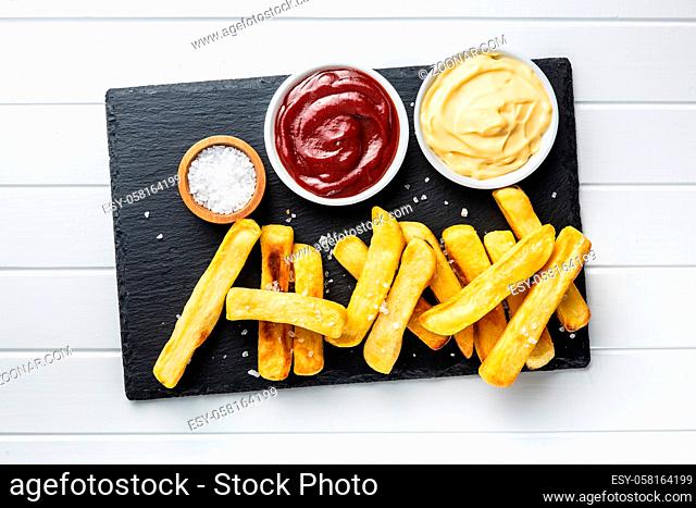 Big french fries. Fried potato chips with ketchup and mayo. Top view
