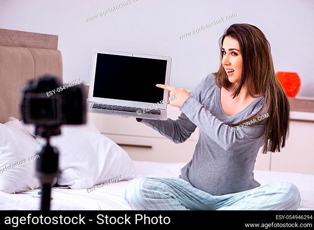 Pregnant woman recording video for her blog