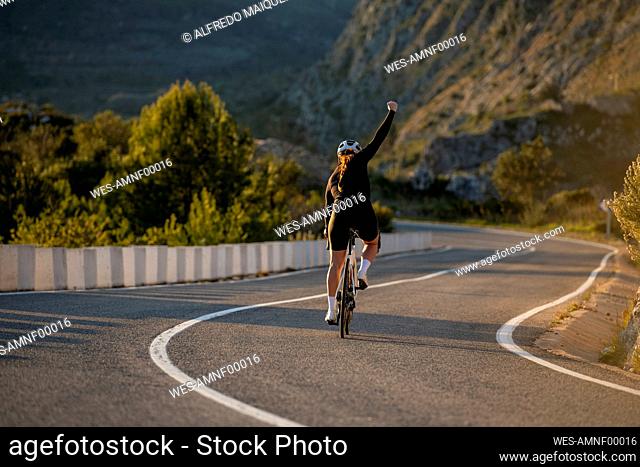 Cheerful cyclist riding cycle on Costa Blanca mountain pass in Alicante, Spain