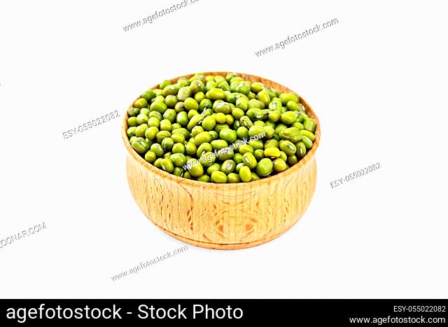 Green lentils mung in a wooden bowl isolated on white background