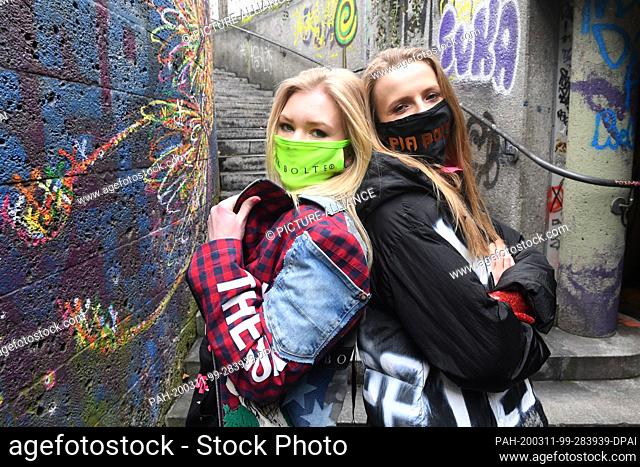 11 March 2020, Bavaria, Munich: The models Klarika Koly (l) and Verena Schmidl (r) present themselves with the colourful