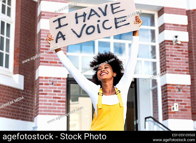 Portrait of mixed race woman holding placard