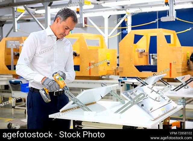 Prime Minister Alexander De Croo uses an electrical screwdriver during a visit to the Volvo Car Academy and the Volvo Car Gent production site, in Gent