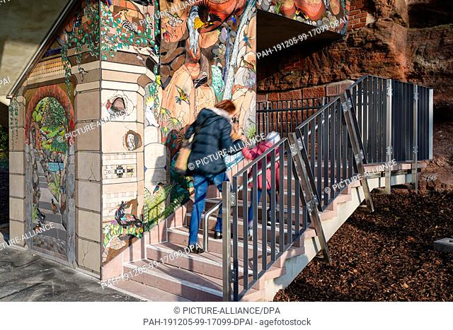 05 December 2019, Rhineland-Palatinate, Pirmasens: Pedestrians climb the stairs during the presentation of what is probably the largest mosaic in...