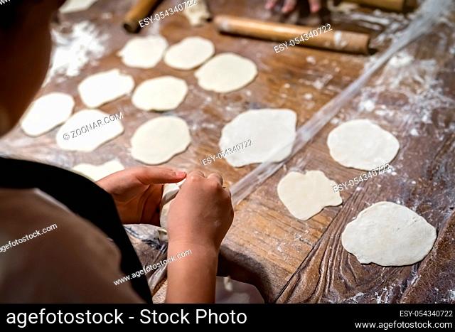 Girl learning to make traditional chinese dumplings during cooking class in a travellers hostel, Chengdu, Sichuan Province, China