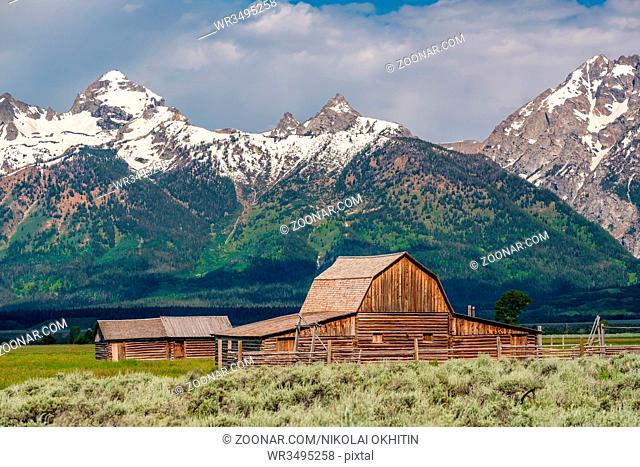 Old mormon barn in Grand Teton Mountains with low clouds. Grand Teton National Park, Wyoming, USA