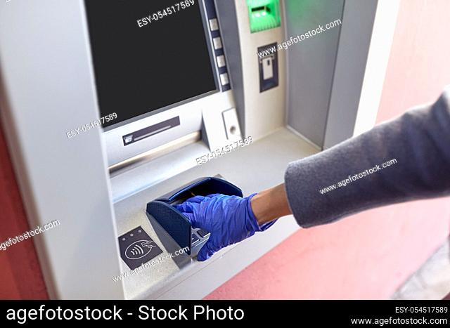hand in medical glove entreing code at atm machine