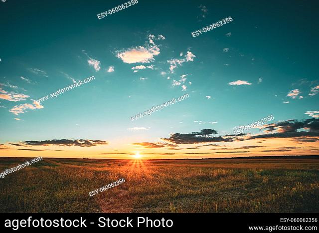 Summer Sunset Sky Above Countryside Rural Meadow Landscape. Sunrise Sun Rising Above Rural Countryside Field