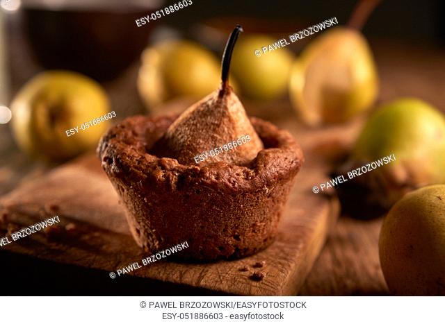 Sweet muffins with pears and agave syrupe on the wooden plank