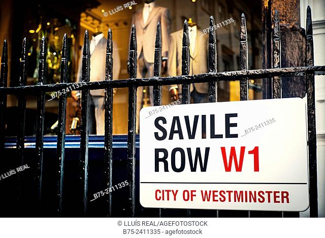 Closeup of a sign of Savile Row Street W1, hung on a Street fence, City of Westminster, with tailoring business in the background