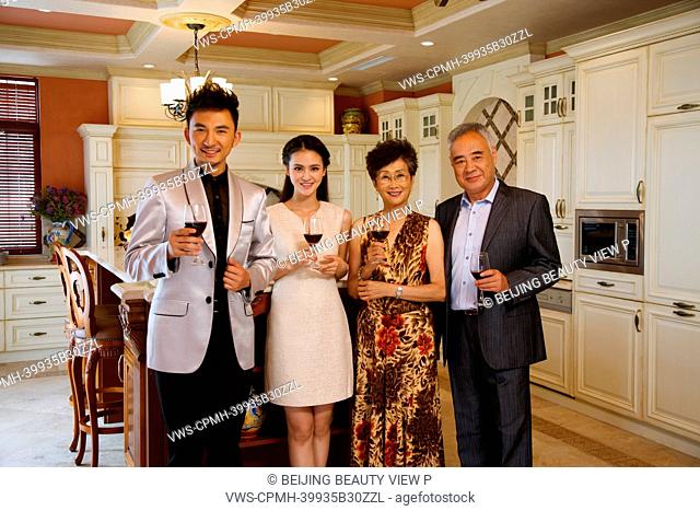 Luxury family holding glasses of red wine