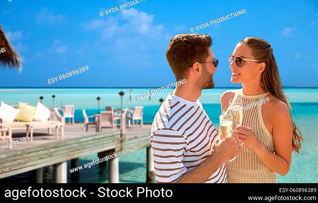 happy couple with champagne over beach restaurant