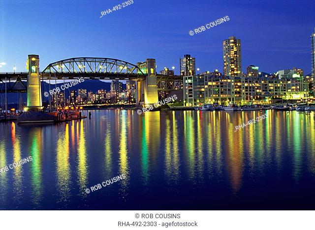 City lights reflected in the water of False Creek, below Burrard Bridge at night, in Vancouver, British Columbia, Canada
