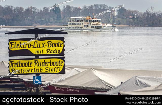09 April 2023, Bavaria, Prien: MS Edeltraud passes a closed boat rental shop on Easter Sunday when entering the Prien-Stock harbor