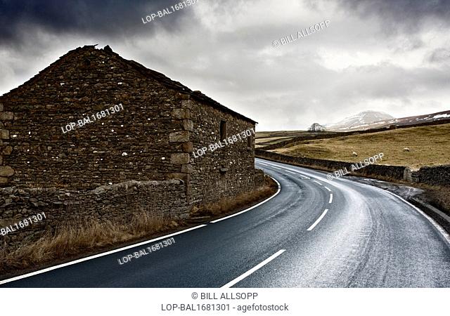 England, North Yorkshire, Horton in Ribblesdale. Winding road leading towards Pen-Y-Ghent seen in the distance