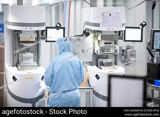 08 September 2020, North Rhine-Westphalia, Hilden: Employees work in protective suits in a laboratory of the biotech company Qiagen