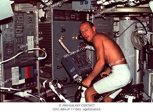 Astronaut Charles Conrad Jr., Skylab 2 commander, during an exercise session on the bicycle ergometer in the crew quarters of the Skylab Orbital Workshop (OWS)...