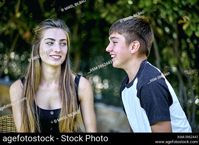 Portrait of a young caucasian woman with her brother posing outdoor in a garden. Lifestyle concept