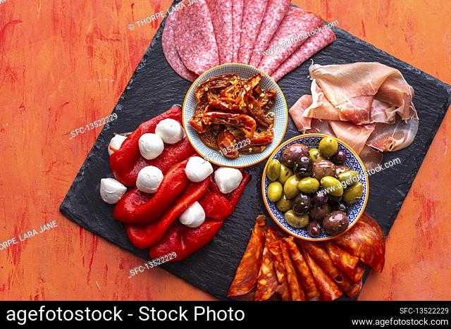 Charcuterie with chorizo, mozzarella, olives, ham, peppers, salami and tomatoes