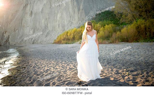 Bride in wedding dress on beach at sunset, Scarborough Bluffs, Toronto, Canada