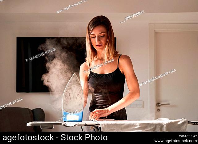 young woman, home, ironing, stereotype