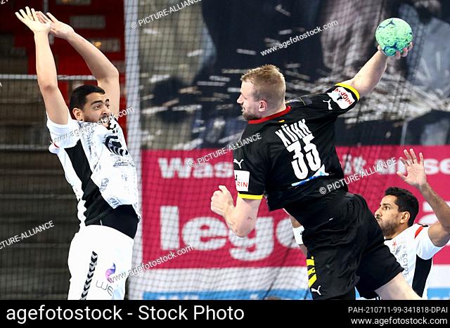 11 July 2021, Bavaria, Nuremberg: Handball: International match, Germany - Egypt in the Arena Nürnberger Versicherung. Ahmed Hesham (l) from Egypt tries to...