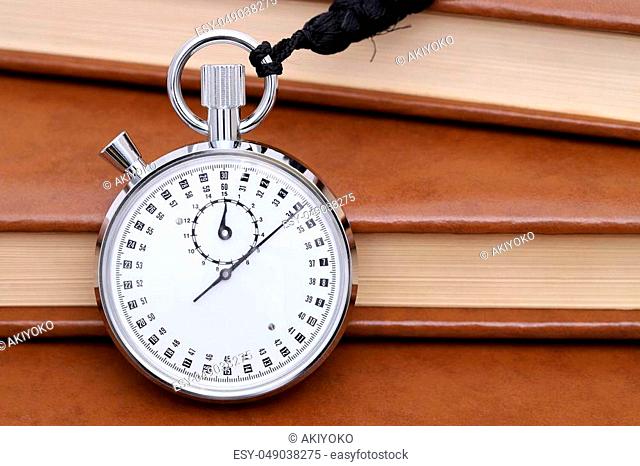analogue stopwatch with old books background
